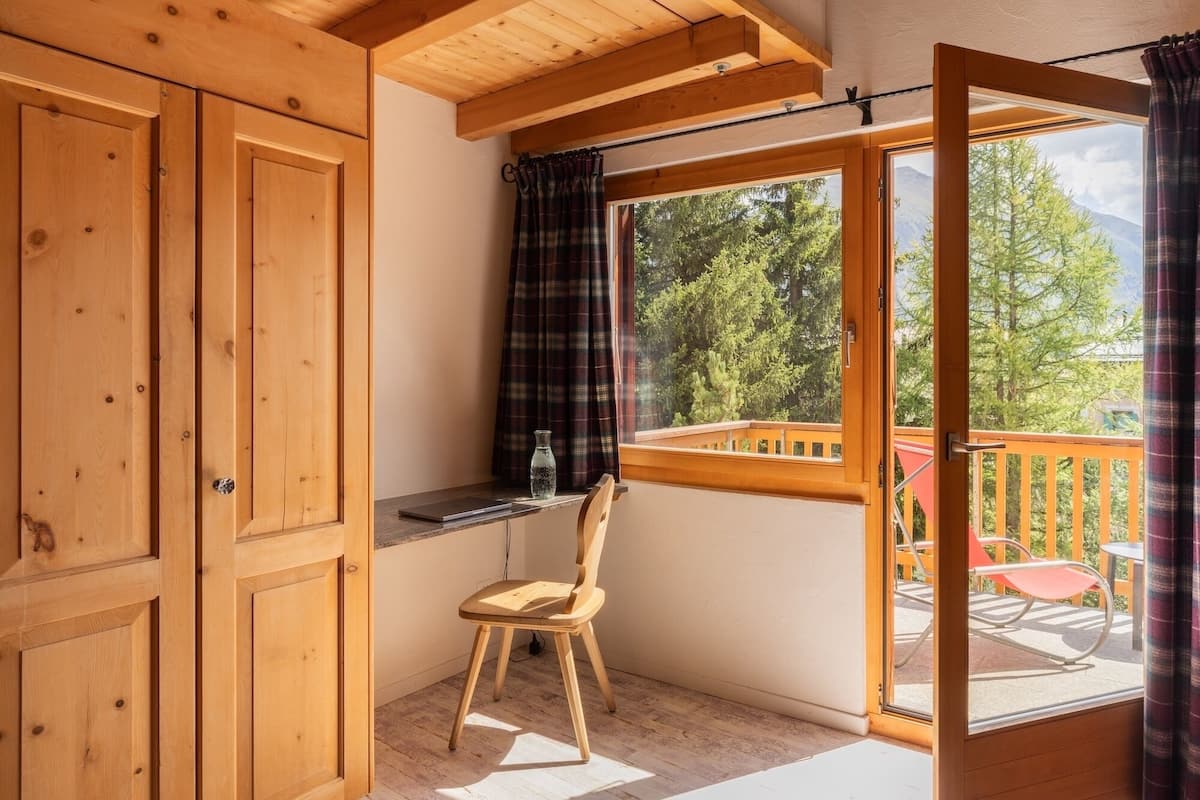 A wooden room with a sliding glass door leading to an outdoor deck.