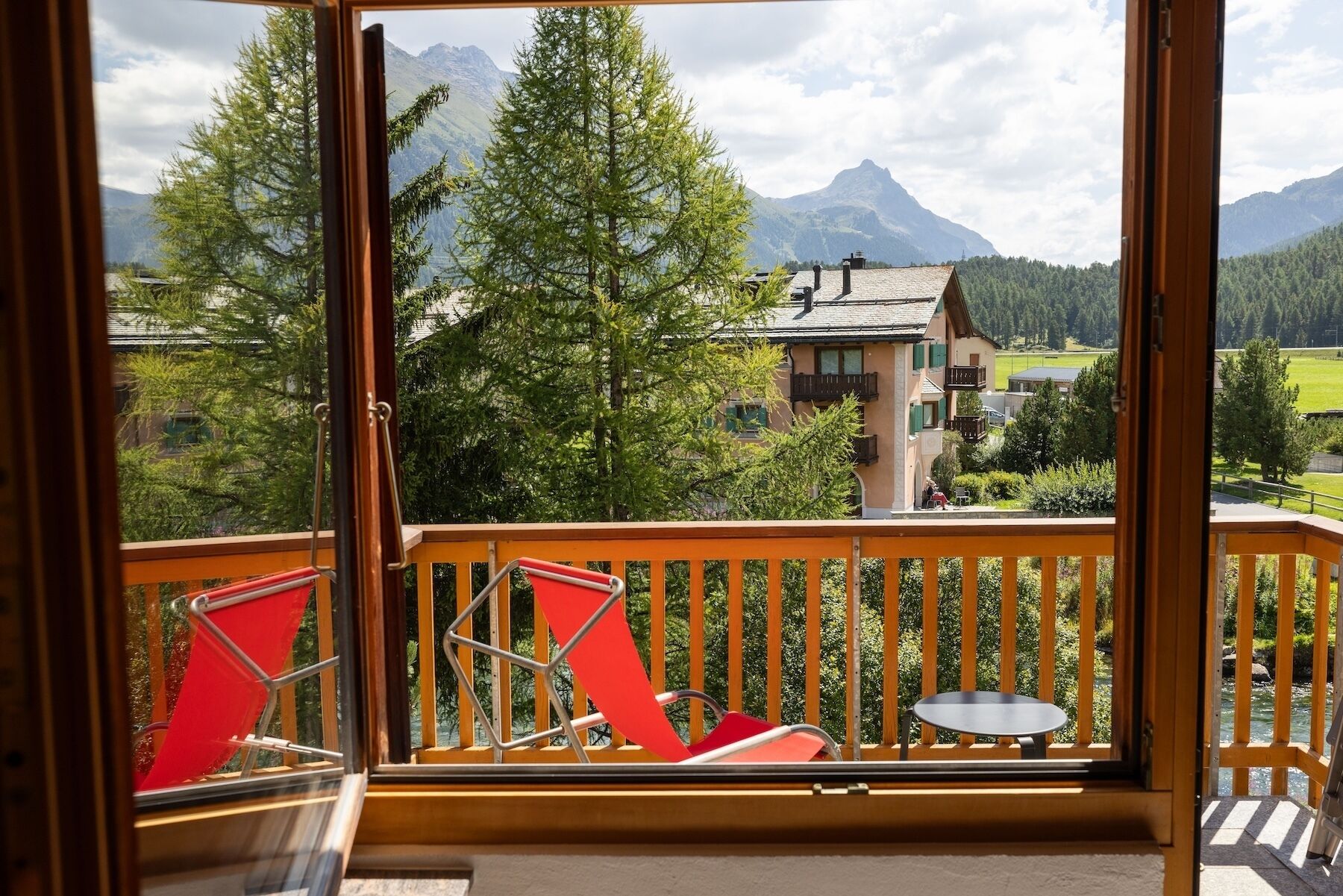 Un balcón con vista a una montaña y una casa.