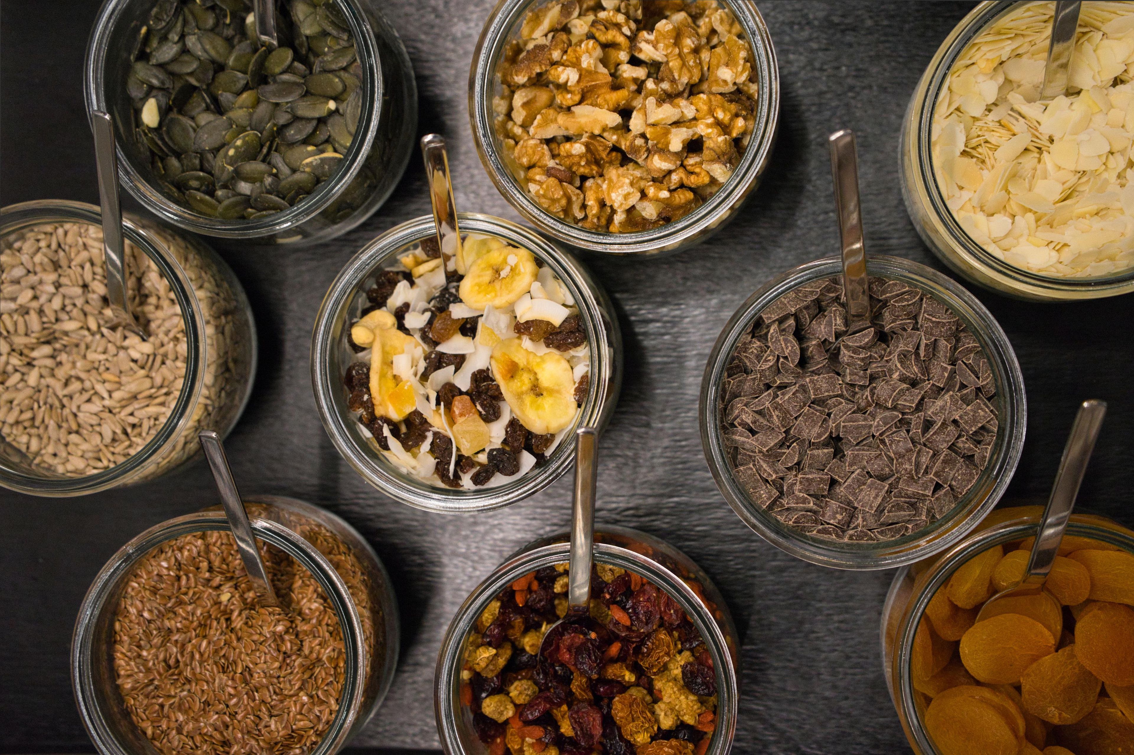 Diversos alimentos en recipientes de vidrio con cucharas.