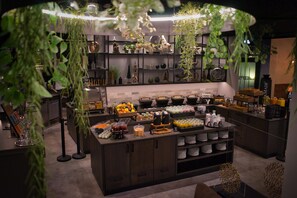 A modern kitchen with a central island, various food items, and decorative plants. - Best Western Plus Hotel Regence (Aachen)