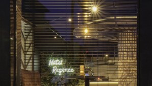 A modern building with a large window displaying a neon sign reading "Hotel Regency." - Best Western Plus Hotel Regence (Aachen)