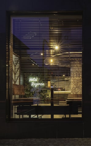 A modern building with a large window displaying a neon sign reading "Hotel Regency." - Best Western Plus Hotel Regence (Aachen)