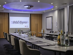 A conference room with a long table, chairs, and a presentation screen displaying 'Hotel Regency.' - Best Western Plus Hotel Regence (Aachen)