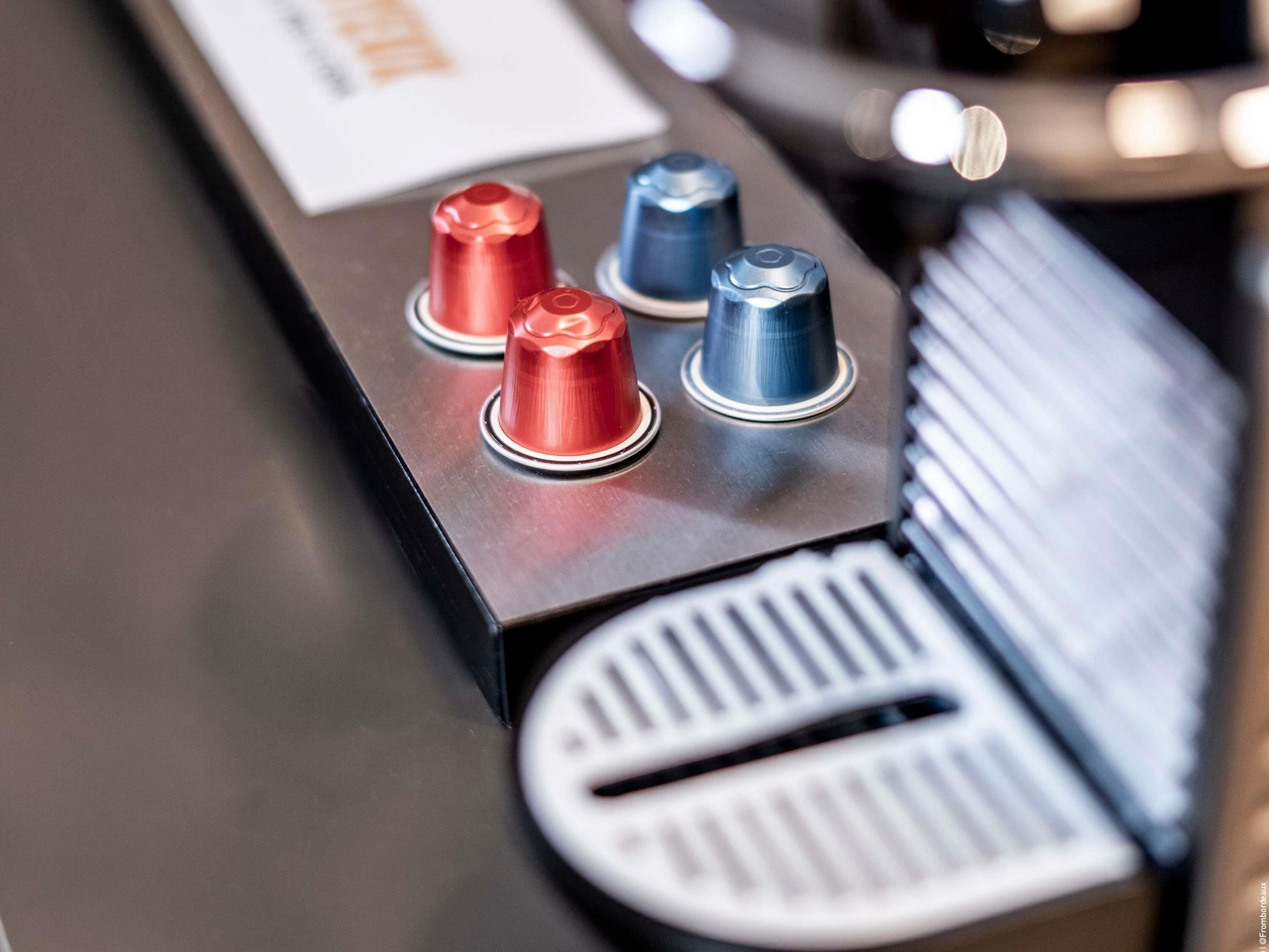 Gros plan d’un panneau de commande avec trois boutons métalliques, une grille d’aération et un clavier partiellement visible.