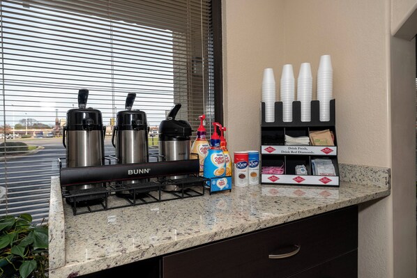 Una kitchenette equipada con una máquina de café Bunn, una máquina de café Nespresso y un dispensador de café Red Diamond.