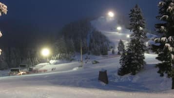 A snowy mountain scene with a ski lift and snow-covered trees.
