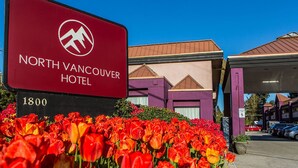 Letrero del Hotel North Vancouver con logotipo de montaña, rodeado de alegres tulipanes.