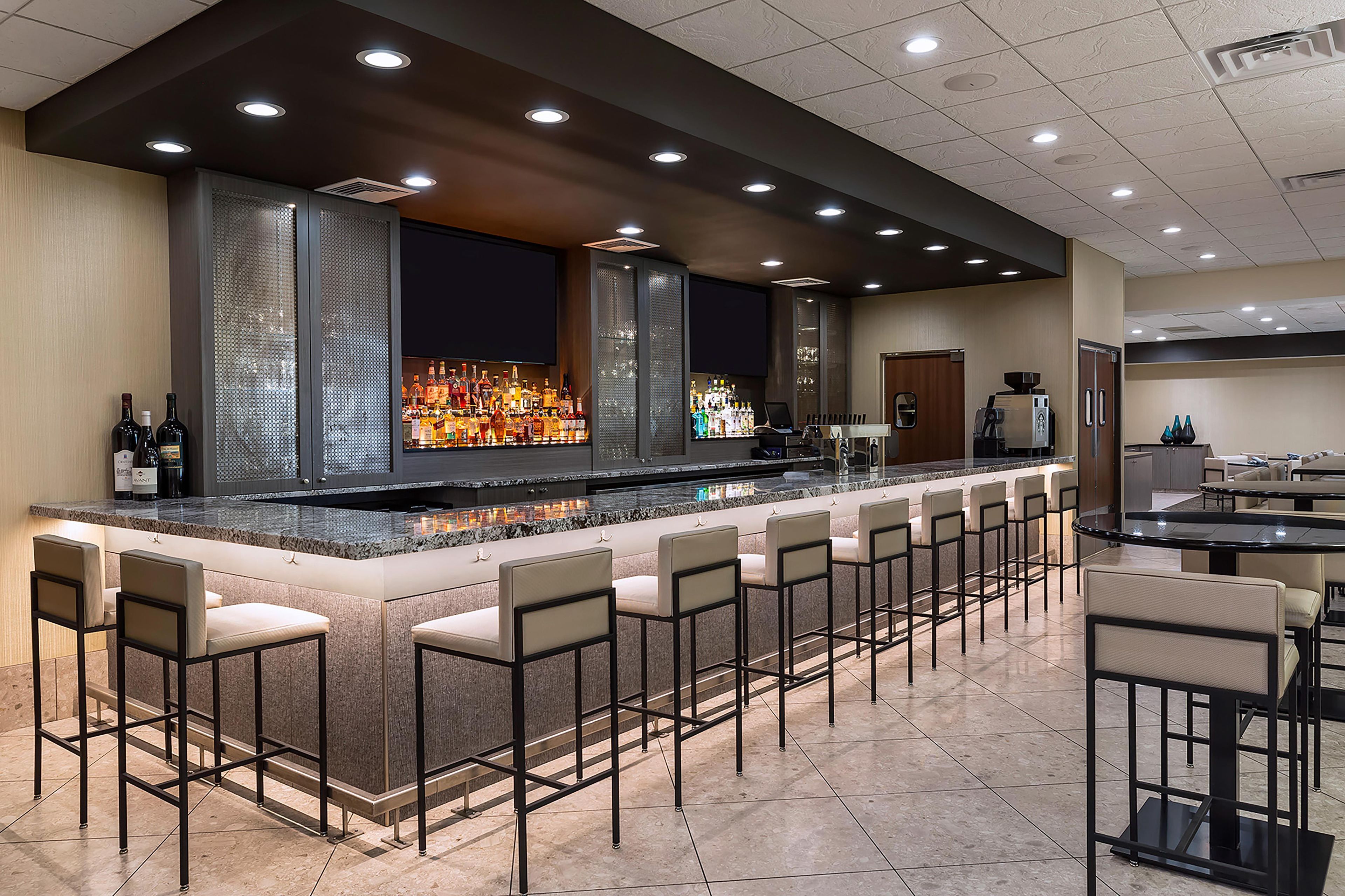 A bar area with a long counter, multiple seating options, and a modern design.