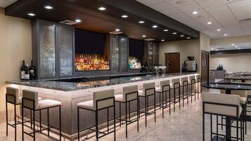 A bar area with a long counter, multiple seating options, and a modern design.