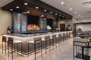 A bar area with a long counter, multiple seating options, and a modern design.