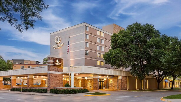 A DoubleTree by Hilton hotel with a brick facade, multiple floors, and a covered entrance area.