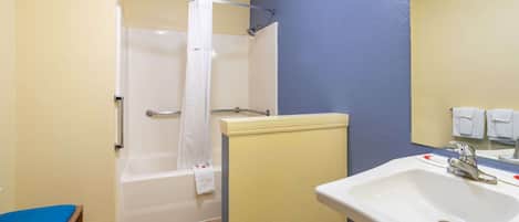 Un baño con bañera, lavabo y espejo.