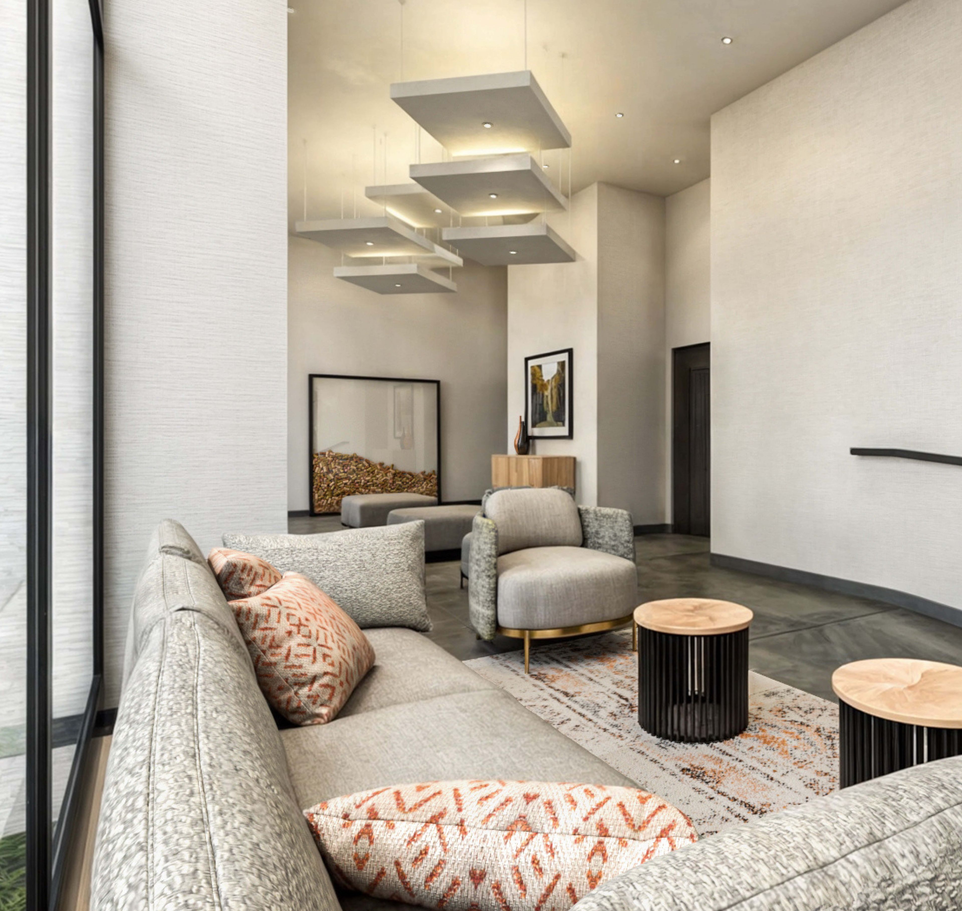 Una sala de estar moderna con un sofá gris, cojines estampados, una mesa de centro de madera y una alfombra.