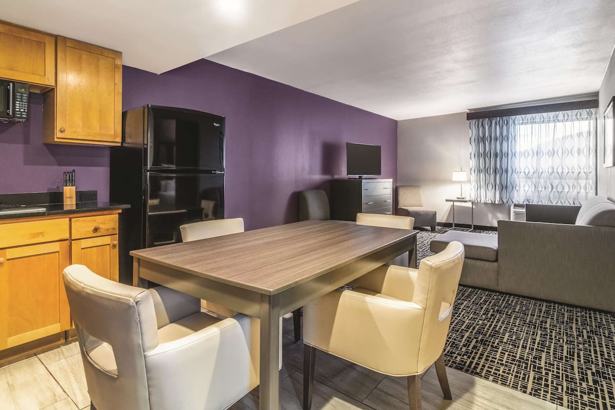 Une chambre d’hôtel compacte comprenant un coin cuisine, un espace repas et un coin salon.