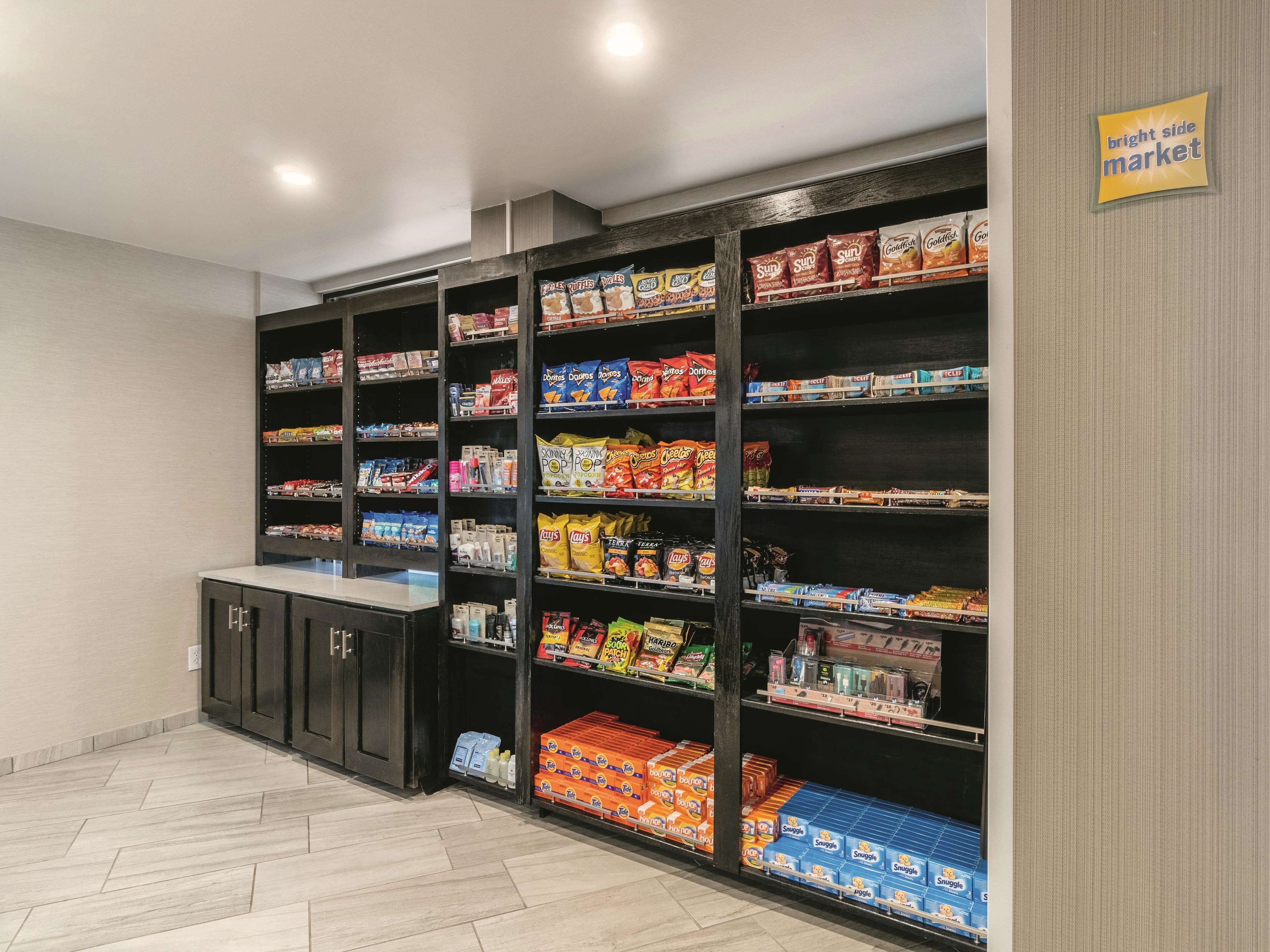 A grocery store interior with shelves stocked with snacks and beverages.