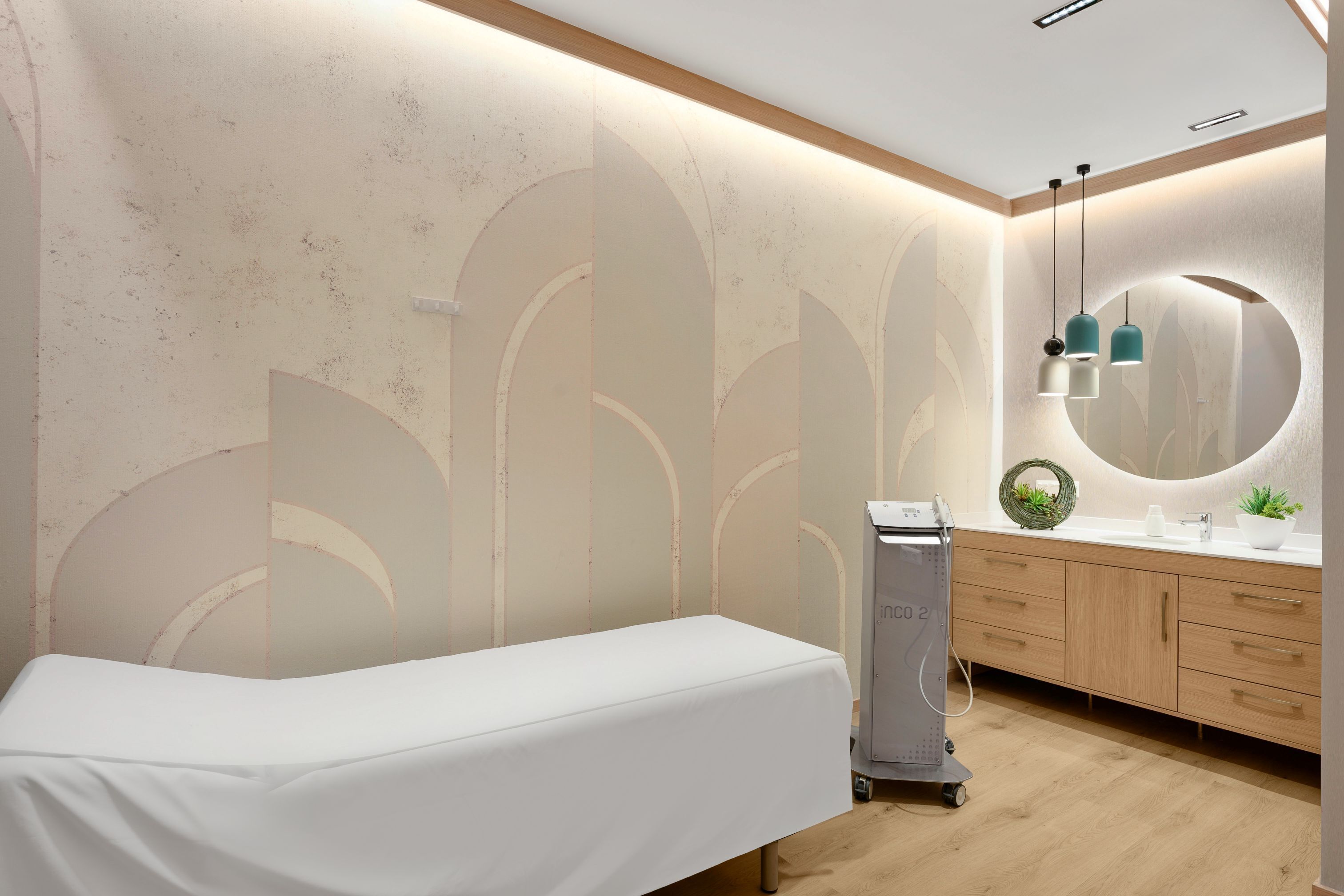 A room with a bed, a wooden cabinet, a mirror, and a small plant.