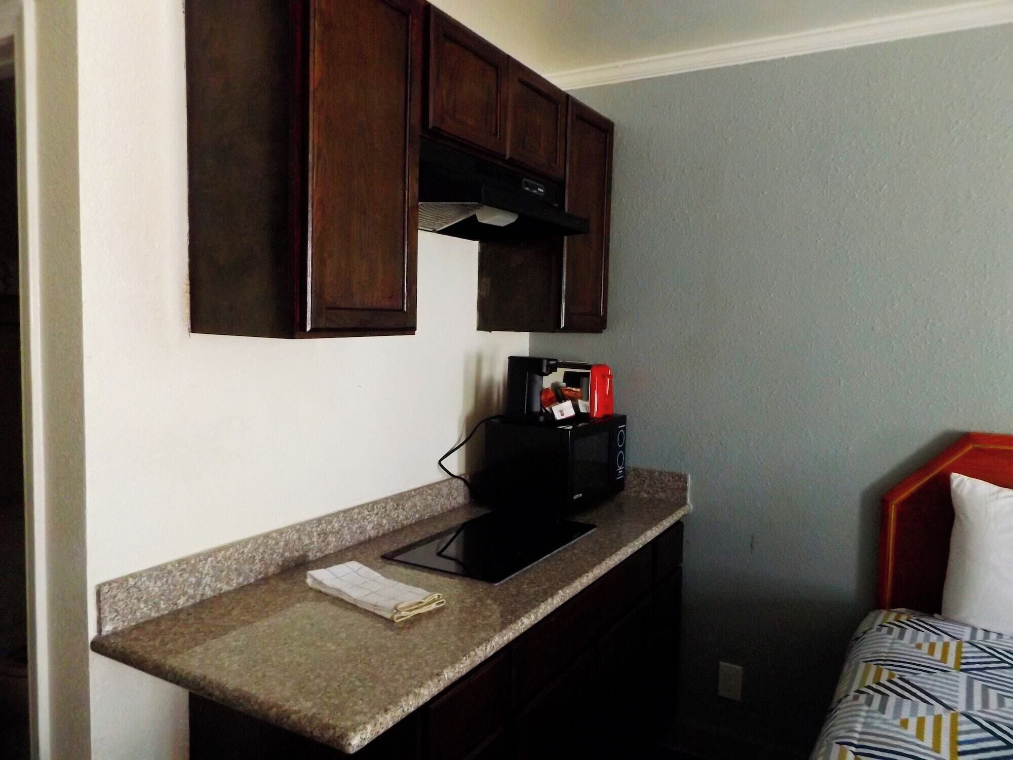 A small kitchenette with a microwave, a coffee maker, and a countertop.