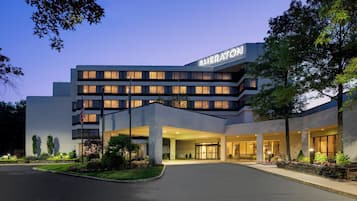 Welcome to the Sheraton hotel, featuring a prominent entrance and beautifully landscaped gardens.