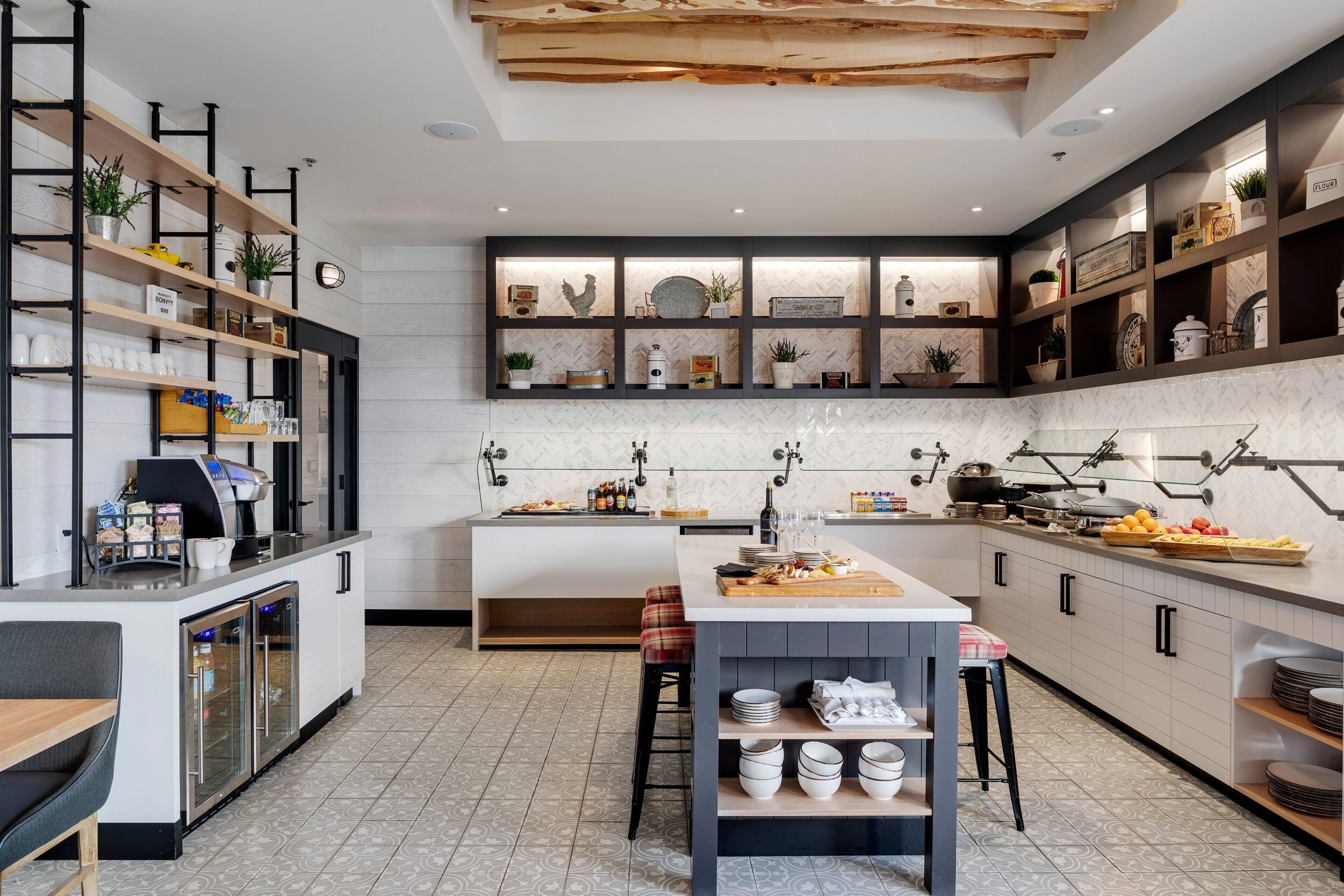 A modern kitchen with a central island, built-in shelves, and a coffee machine.