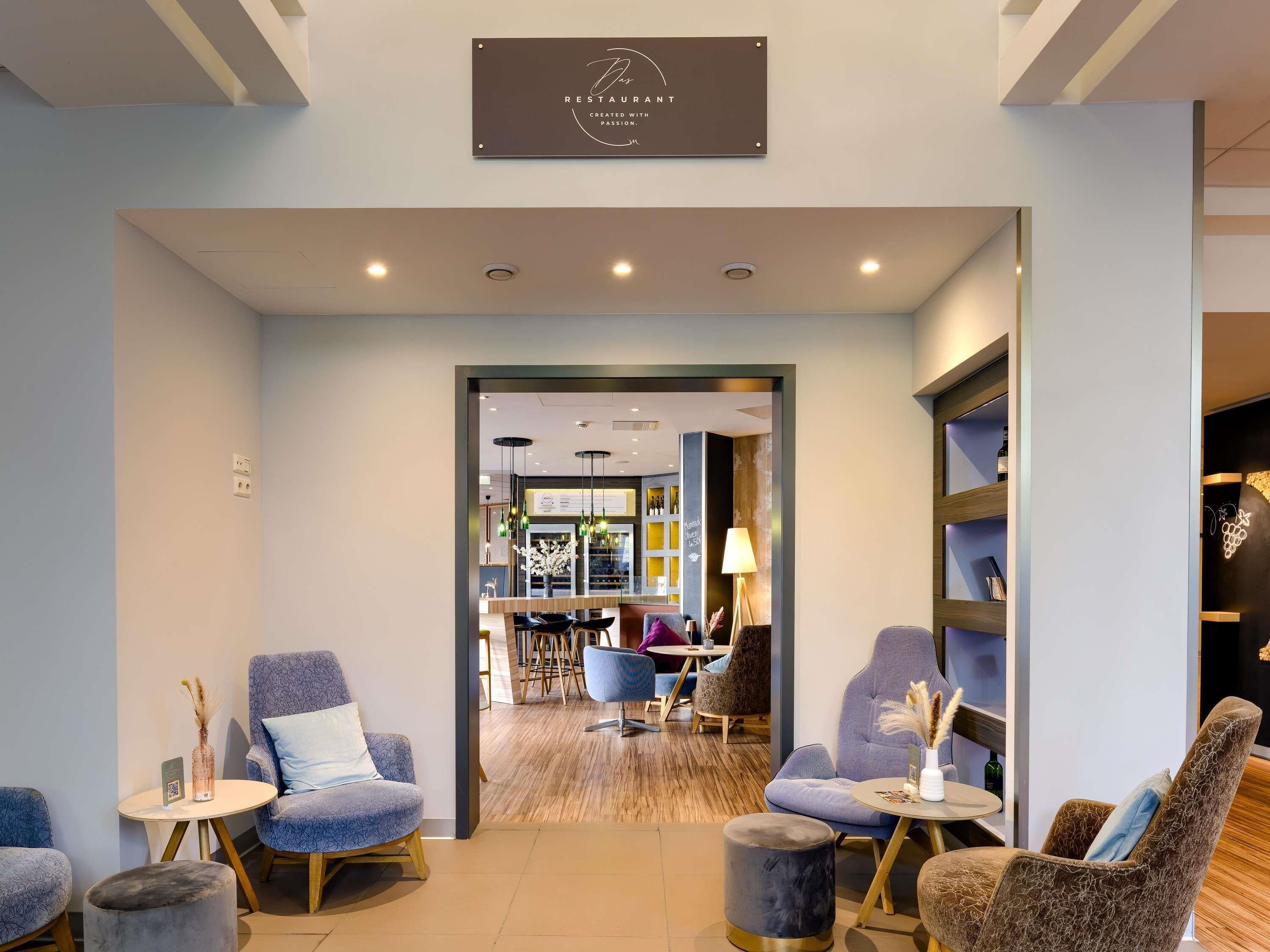 Un interior moderno con zonas de estar, un mostrador de recepción y una vinoteca visible.