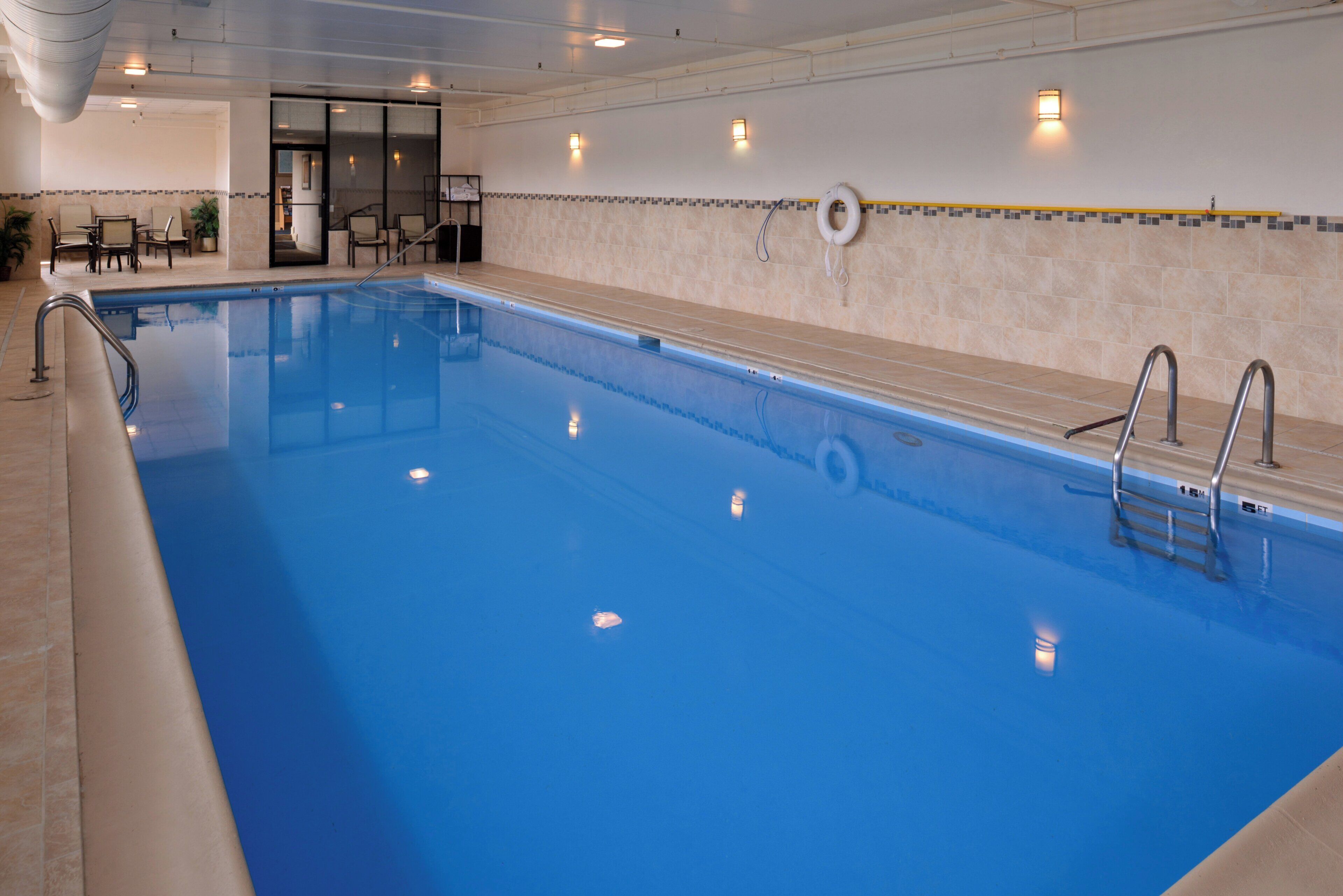 Ein großer, überdachter Pool mit klarem Wasser, umgeben von einer mit Verzierungen versehenen Fliesenwand.