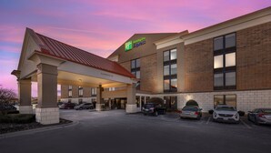 A Holiday Inn Express building with a covered entrance and a parking lot.