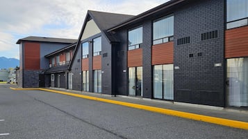 En moderne bygning med facade af mursten, store vinduer og fladt tag.