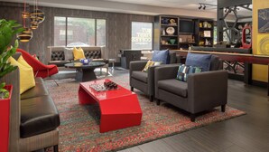 A modern living room with a red coffee table, grey sofas, and a large window. - Staypineapple, Hotel FIVE, Downtown Seattle (Seattle)
