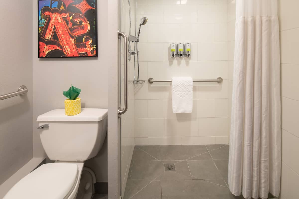 A bathroom with a toilet, a shower, and a towel rack.