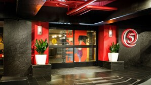 A modern building entrance with a red and black color scheme, a glass door, and a number '5' sign. - Staypineapple, Hotel FIVE, Downtown Seattle (Seattle)