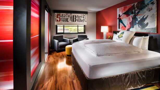 A modern hotel room with a large bed, a sofa, a small table, and a window with a view. - Staypineapple, Hotel FIVE, Downtown Seattle (Seattle)