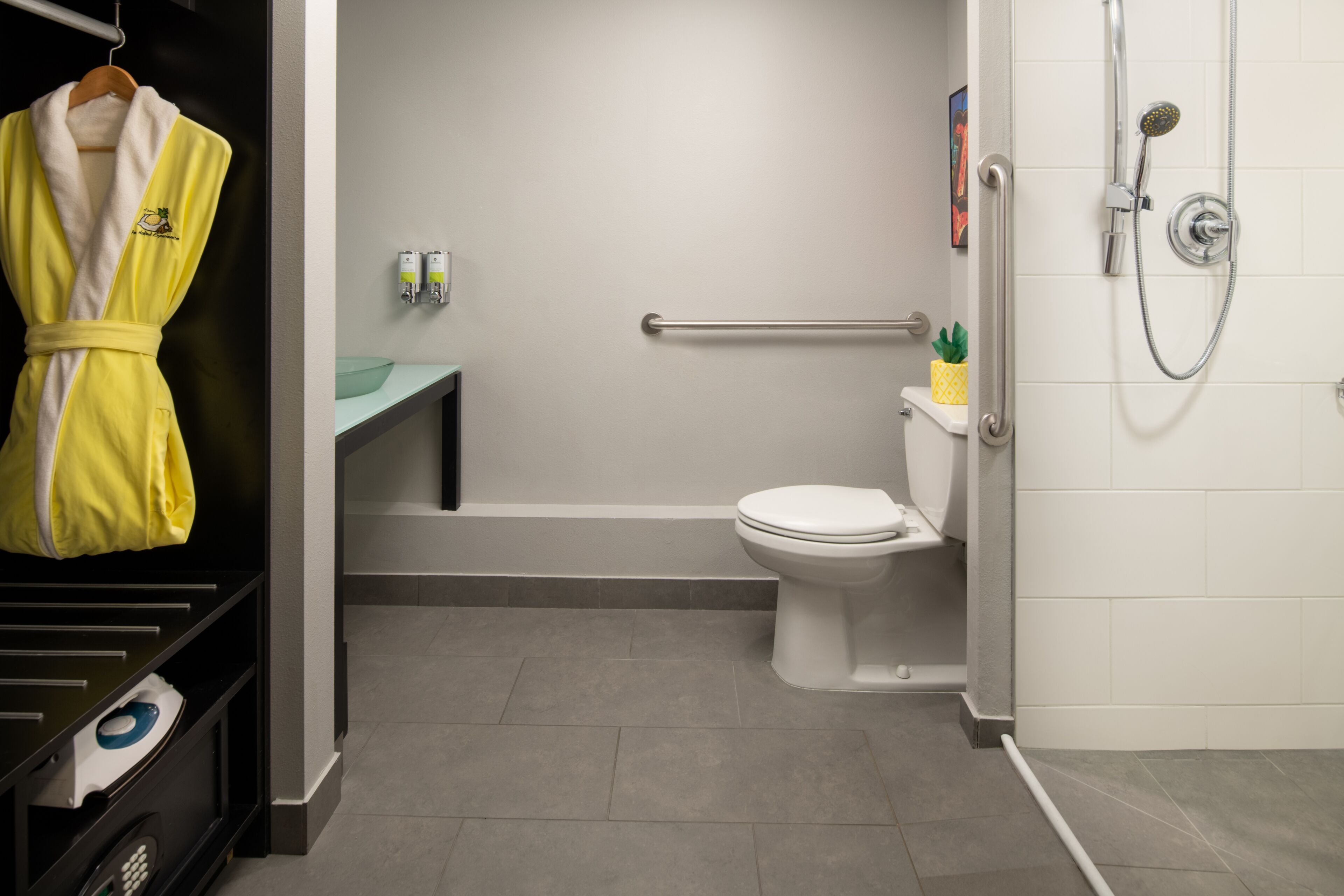 Une salle de bain équipée de toilettes, d’une douche, d’un porte-serviettes et d’un lavabo.