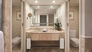A bathroom with a marble sink, two toilets, a bidet, and a large mirror.