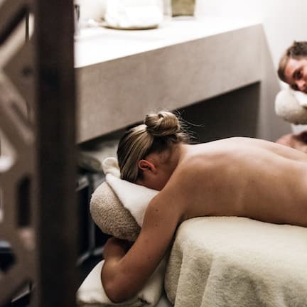 A spa treatment room with a massage table and a counter in the background.
