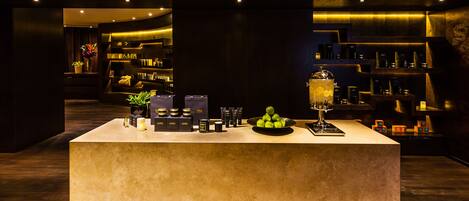 A reception area with a counter displaying products, a decorative lamp, and a potted plant.