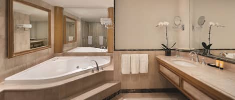 A modern bathroom with a large bathtub, two sinks, and multiple mirrors.