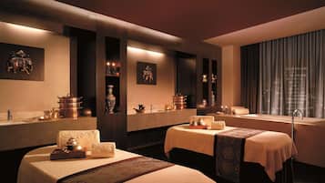 Une chambre d’hôtel avec deux lits, un grand miroir et une baignoire.