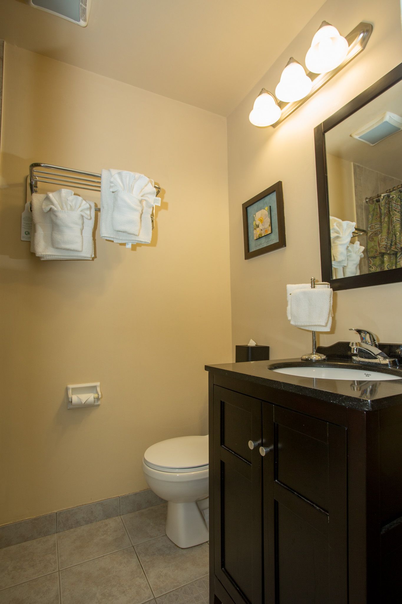 A bathroom with a toilet, sink, and towel rack.