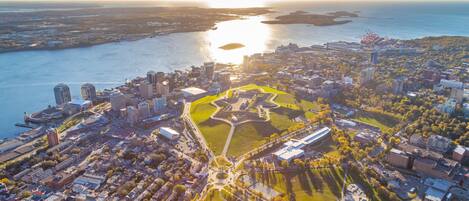 An aerial view of a coastal city with a central park, surrounding buildings, and a body of water.