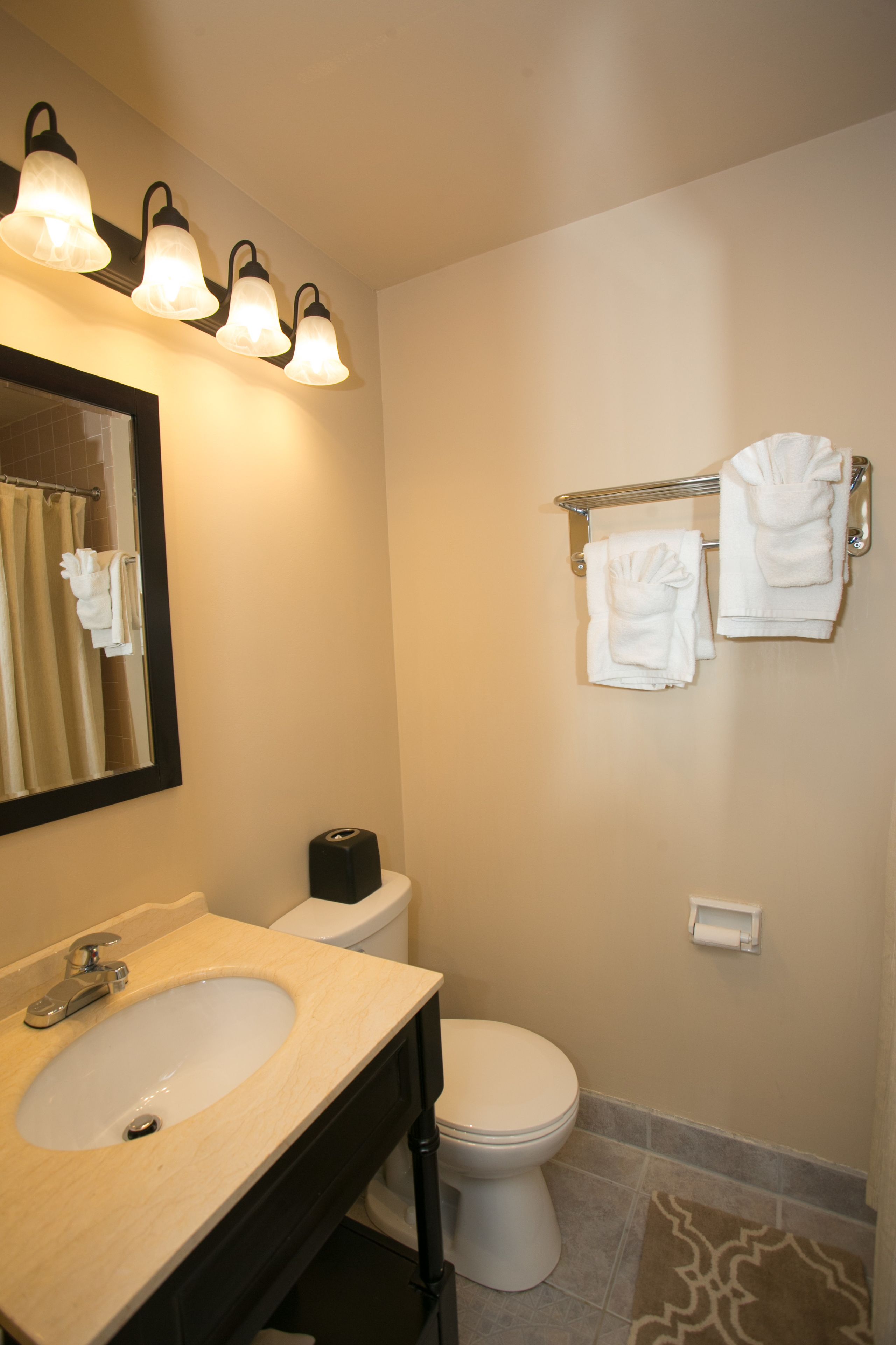 A bathroom with a sink, mirror, and towel rack.