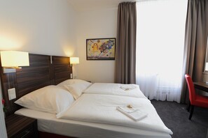 A hotel room with a bed, two bedside lamps, a painting on the wall, and a red chair. - Best Western Hotel Kaiserhof (Bonn)