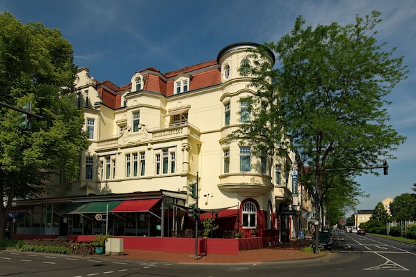 A historic building with a red awning, large windows, and a corner turret.