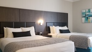 A hotel room with two beds, dark wood headboards, white bedding, and a wall-mounted light fixture. - Best Western Laval-Montreal (Laval)