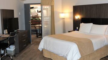 Una habitación de hotel con cama, escritorio, silla y televisión.