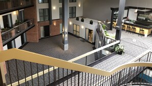 A multi-level atrium with a central open area, multiple balconies, and a kitchen area with bar seating. - Best Western Laval-Montreal (Laval)