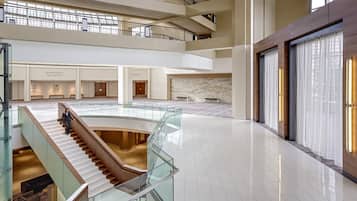 Un amplio atrio con una escalera de cristal, varias zonas de estar y la sala de baile Grand Mesa.