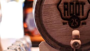 A taphouse & kitchen with a wooden barrel labeled "ROOT" and a sign for "Apple Smoked Fireside Whiskey".