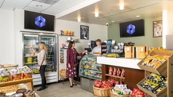A bakery counter with a display case, shelves with packaged goods, and baskets of items.