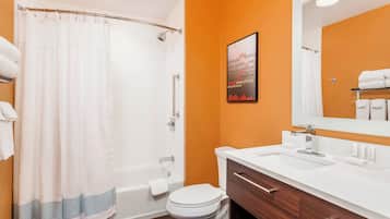 A bathroom with a bathtub, toilet, and sink.