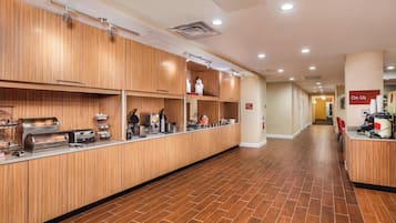 A long, narrow hotel corridor with wooden paneling on the walls and a tiled floor.